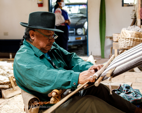 Ecuadorian man demonstrating traditional weaving techniques on a loom