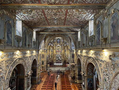 inside of iglesia de la compania church in Quito, with ornate carvings and lots of intricate gold leaf decorations