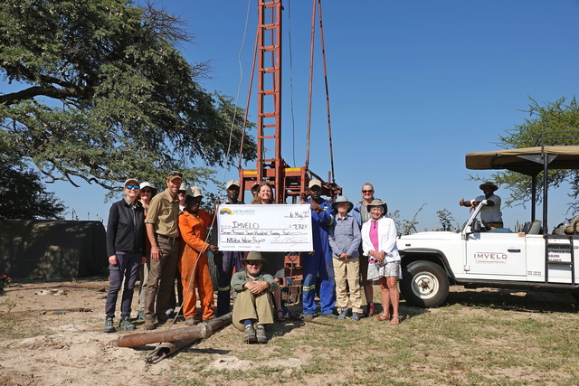 a group of donors with a giant check representing the donation they made to fund a new well in rural Zimbabwe