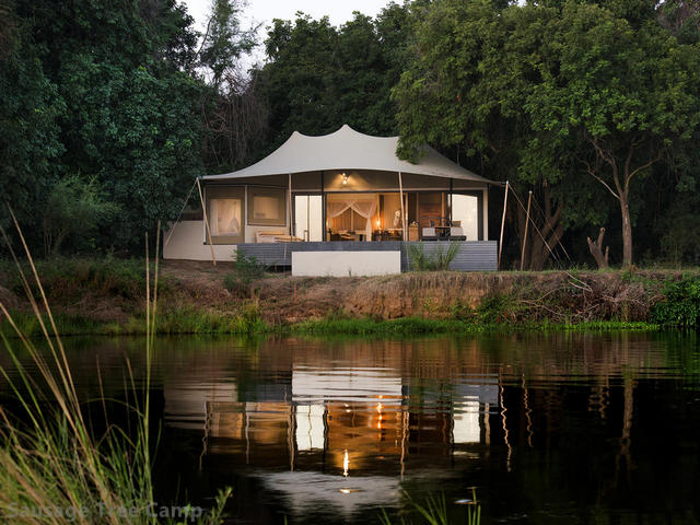 Luxury canvas tent on the river reflecting in the water at Sausage Tree, a luxury safari camp in the Lower Zambezi, Zambia