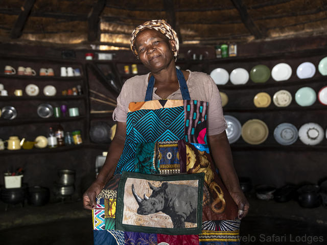 A local woman gives safari guests a tour of her home adjacent to Hwange National Park in Zimbabwe