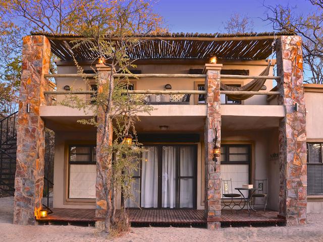 Exterior view of a stone guest chalet at Camelthorn Lodge, a luxury safari camp in Hwange National Park Zimbabwe