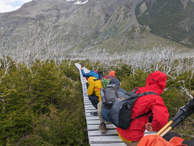 Hikers crouch on a boardwalk to seek protection from strong winds on the Mirador Frances hike in Torres del Paine National Park in Chile