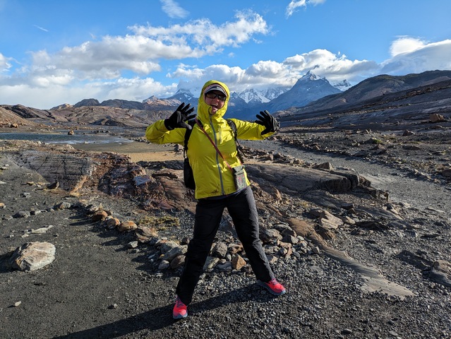 A hiker standing in the windy mountains demonstrating essential hiking gear at the start of the Fossil Canyon hike at Estancia Cristina near Lago Argentina in Patagonia