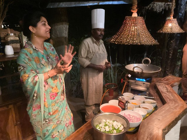 Kanha Jungle Lodge manager Dimple assists the chef in giving a cooking lesson to guests during a luxury tiger safari in India