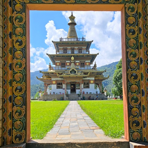 Bhutan's beautiful Khamsum Yulley Namgyal Chorten, a four-story stupa, framed by intricate woodwork.