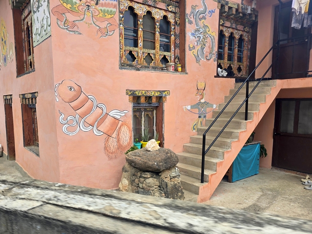 A colorful building in Bhutan's Punakha Valley adorned with artwork showing a large phallus